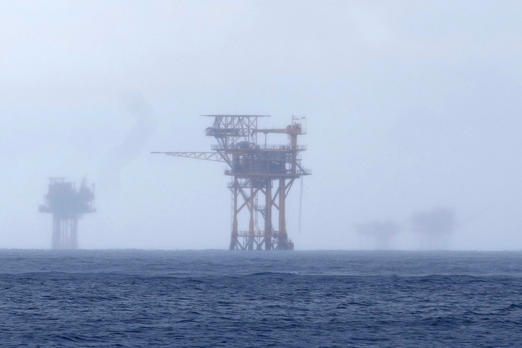 Oil platforms are visible through the haze near the Flower Garden Banks National Marine Sanctuary in the Gulf of Mexico, off the coast of Galveston, Texas, Sept. 16, 2023. Oil companies offered $382 million for drilling leases in the Gulf Wednesday after courts rejected the Biden administration's plans to scale back the sale to protect an endangered whale species.