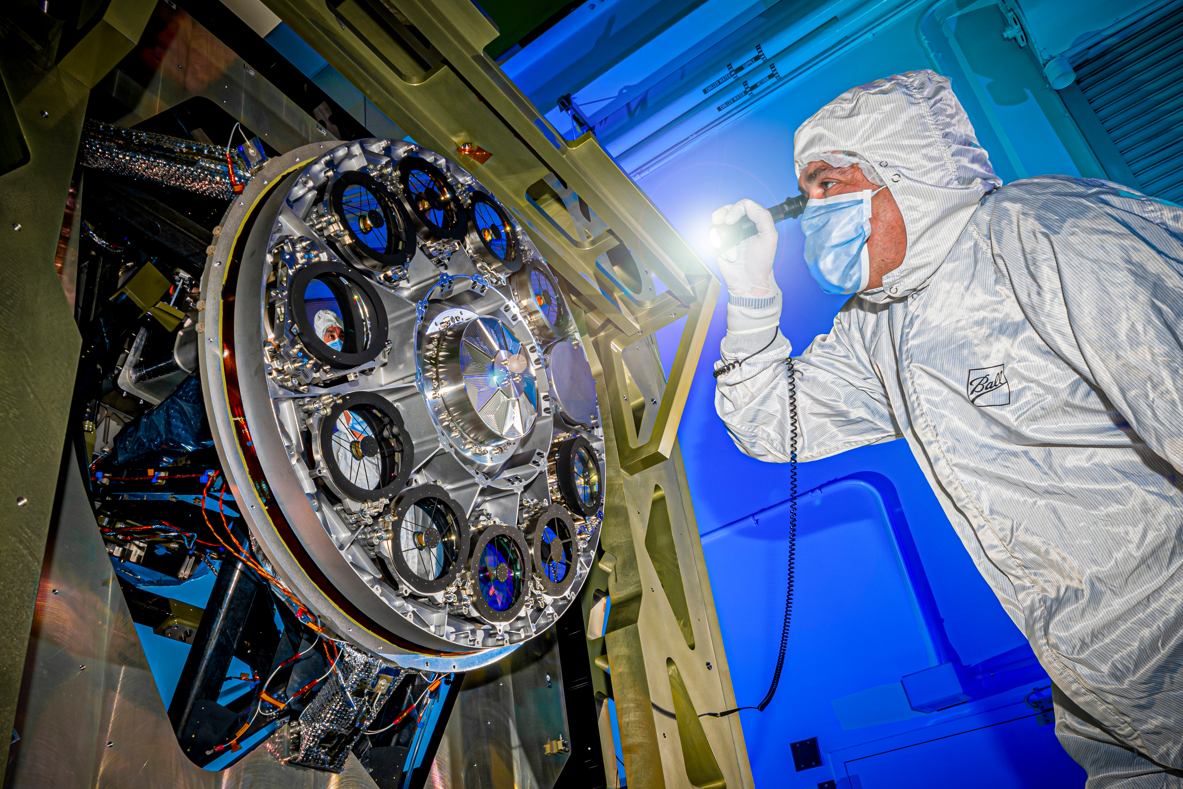 A Ball Aerospace specialist inspects components of the Nancy Grace Roman Space Telescope.
