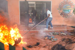 Workers put down a fire at an office of Haiti's power company in Port-au-Prince, March 1, 2024.