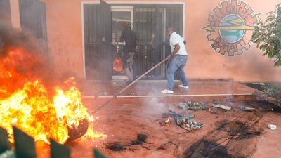 Workers put down a fire at an office of Haiti's power company in Port-au-Prince, March 1, 2024.