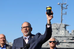 South Carolina Department of Natural Resources Director Robert Boyles holds a jar of toxic waste outside the USS Yorktown at a press conference in Mount Pleasant, S.C., on Tuesday, March 19, 2024. Officials are preparing to remove over 1.2 million gallons of hazardous liquids from the World War II-era aircraft carrier.
