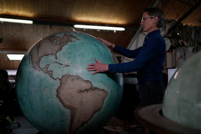 Peter Bellerby, the founder of Bellerby & Co. Globemakers, holds a globe at a studio in London, Tuesday, Feb. 27, 2024.