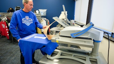 Brent Kisha, STAHLS' vice president of strategic sales, demonstrates using a Hotronix Fusion IQ heat press to put a name on shirt in St. Clair Shores, Mich., Monday, April 22, 2024.