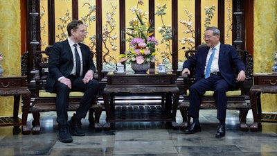 In this photo released by Xinhua News Agency, visiting Tesla founder and CEO Elon Musk, left, meets with Chinese Premier Li Qiang in Beijing, Sunday, April 28, 2024. Musk met with a top government leader in the Chinese capital Sunday, just as the nation's carmakers are showing off their latest electric vehicle models at the Beijing auto show.