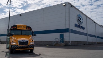 An all-electric school bus sits on display in front of the Blue Bird Corp. factory in Fort Valley, Ga., on Feb. 8, 2023.