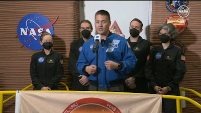 NASA Deputy Director of Flight Missions Kjell Lindgren speaks in front of the crew members of the first CHAPEA mission.