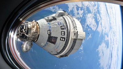 This photo provided by NASA shows Boeing's Starliner spacecraft which launched astronauts Butch Wilmore and Suni Williams to the International Space Station docked to the Harmony module's forward port on July 3, 2024, seen from a window on the SpaceX Dragon Endeavour spacecraft docked to the adjacent port.