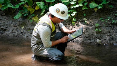 A Environmental Protection Agency worker works in Leslie Run in East Palestine, Ohio, June 12, 2024.