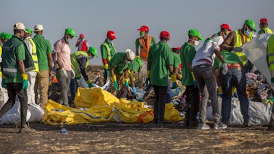 Workers collect debris on March 12, 2019 at the scene where an Ethiopian Airlines Boeing 737 Max 8 crashed shortly after takeoff, killing all 157 on board, near Bishoftu, or Debre Zeit, south of Addis Ababa, in Ethiopia.