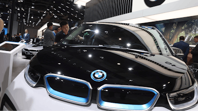 A worker cleans an electric vehicle at the BMW booth during the Auto Shanghai 2019 show in Shanghai on April 17, 2019.