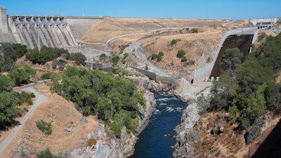 The American River flows out of the Folsom Dam, Friday, Aug. 16, 2024, in Folsom, Calif.