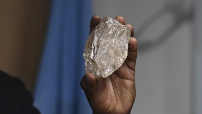 A person holds a 2,492-carat diamond which was found in the country and on show, in Gaborone, Botswana, Thursday, Aug. 22, 2024.