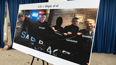 A photo of Russian suspects wanted by the FBI involved in a conspiracy to commit criminal cyber activities against Ukrainian government systems is displayed during a press conference at the Office of the United States Attorney in Baltimore, Thursday, Sept. 5, 2024.