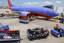 Baggage carts are towed to the Boeing 737 jet at Bill and Hillary Clinton National Airport in Little Rock, Ark.