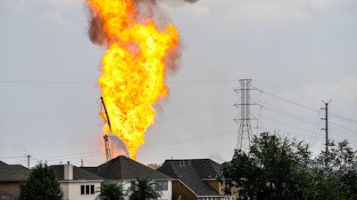 A firefighter directs a line of water around a fire on a pipeline carrying liquified natural gas near Spencer Highway and Summerton on Monday, Sept. 16, 2024, in La Porte, Texas.