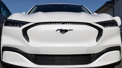 Ford Mustang Mach-E SUV display at a charging station.