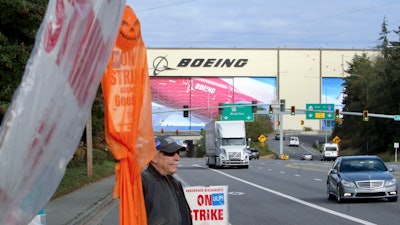 Union machinist Terry Muriekes waves a Halloween-decorated strike sign by Boeing's Everett, Wash., factory on Tuesday, Oct. 22, 2024.