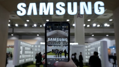 A visitor takes a picture of the logo of Samsung Electronics at its booth during The Semiconductor Exhibition 2024 at the COEX convention center in Seoul, South Korea, Wednesday, Oct. 23, 2024.