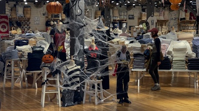A woman shops at a fashion boutique decorated with Halloween in Beijing, Thursday, Oct. 31, 2024.