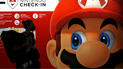 A traveler walks past an advertisement featuring a Nintendo character at Narita airport in Narita near Tokyo, on June 10, 2022.