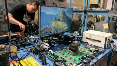 Employees work behind an evaluation board, foreground, in a lab at the d-Matrix office in Santa Clara, Calif., Wednesday, Oct. 16, 2024.
