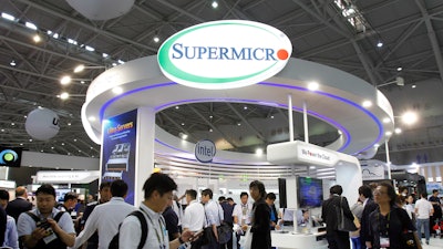 Visitors walk past the 'Super Micro' both at the Computex Taipei exhibition, one of the world's largest IT expos, in Taipei, Taiwan, Tuesday, June 5, 2018.