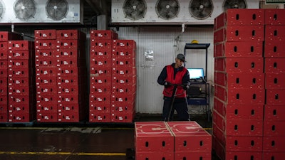 A worker organizes boxes of flowers intended for export to the U.S. at a flower farm in Chia, Colombia, Jan. 27, 2025.