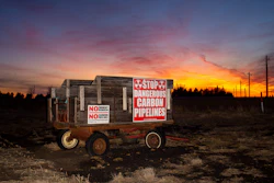 A wagon covered in signs protesting the installation of a Summit Carbon Solutions pipeline stands on a farm in Lake County, S.D., on Monday, March 10, 2025, in one of the counties that the pipeline would cut through.