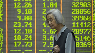 An investor stands in front of stock price indices at a brokerage house, Hangzhou, China, April 7, 2025.