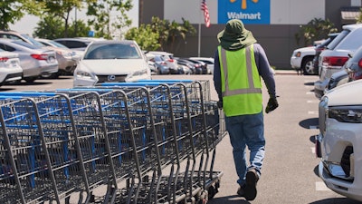 Empty shopping carts are collected from the parking lot at Walmart store in Burbank, Calif., on Thursday, April 10, 2025.