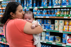 Yury Navas, 29, of Laurel, Md., kisses her two-month-old baby Jose Ismael Gálvez, at Superbest International Market, Laurel, Md., May 23, 2022.
