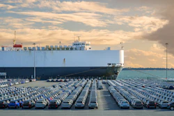 A large auto carrier ship sits at a port. Known as RO-RO vessels, these types of carriers can contain thousands of vehicles.