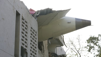 The debris of an airplane sticks out of a building after it crashed in India's northwestern city of Ahmedabad in Gujarat state, Thursday, June 12, 2025.