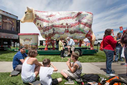 The giant Turkey Hill Cow looms over festival goers sampling ice cream at Taste of Omaha on May 31, 2015, in Omaha, Neb.
