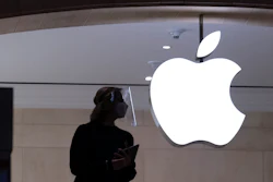 An Apple store employee stands inside the store in New York on Feb. 5, 2021.
