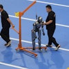 Workers transfer a robot before the opening ceremony for the World Humanoid Robot Games held in Beijing, China, Thursday, Aug. 14, 2025.