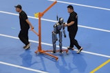 Workers transfer a robot before the opening ceremony for the World Humanoid Robot Games held in Beijing, China, Thursday, Aug. 14, 2025.