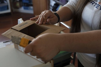 Amanda Follett opens packages at A Sight For Sport Eyes, a brick-and-mortar and e-commerce store for sport goggles, Aug. 20, 2025, in West Linn, Ore.