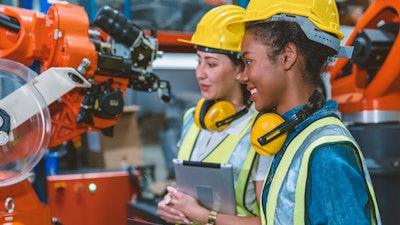 Technicians examine robotic machinery.