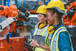 Technicians examine robotic machinery.