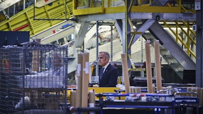 Prime Minister Mark Carney walks through a manufacturing facility ahead of a press conference in Mississauga, Ont., on Friday, Sept. 5, 2025.