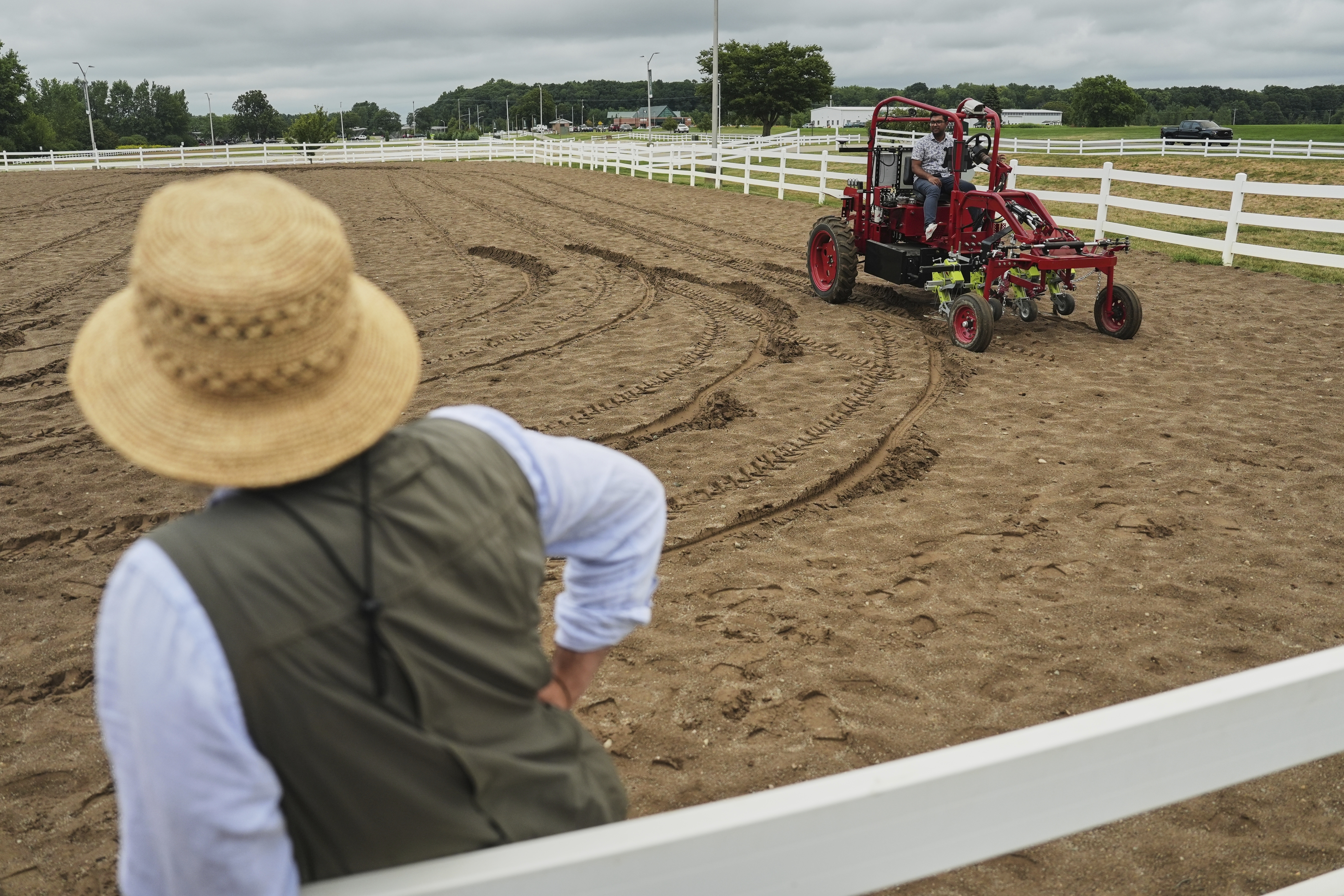 MK Bashar, right, test drives an electric tractor as Ben Phillips, left, watches Tuesday, Aug. 19, 2025, during a demonstration in East Lansing, Mich.