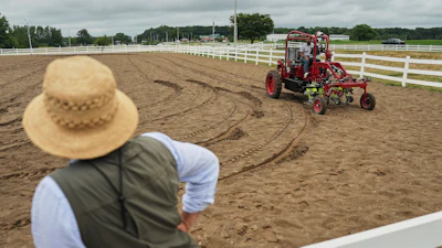 MK Bashar, right, test drives an electric tractor as Ben Phillips, left, watches Tuesday, Aug. 19, 2025, during a demonstration in East Lansing, Mich.