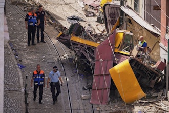 Police officers inspect the site where a tourist streetcar derailed and crashed in Lisbon, Portugal, Thursday, Sept. 4, 2025.