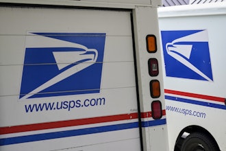 U.S. Postal Service delivery vehicles are parked outside a post office in Boys Town, Neb., Aug. 18, 2020.