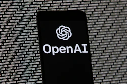 The OpenAI logo appears on a mobile phone in front of a computer screen with random binary data, March 9, 2023, in Boston.