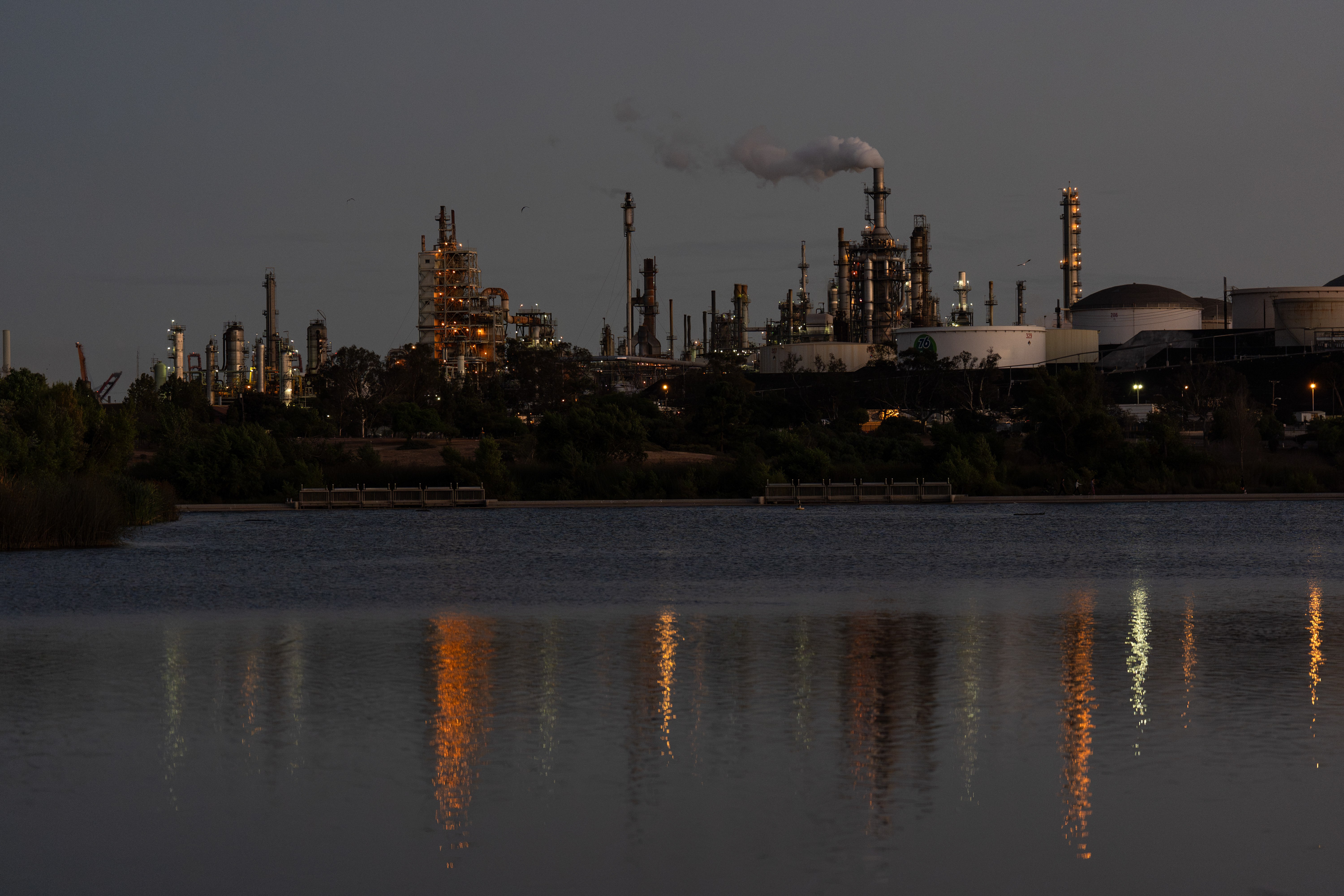 Lights from the Phillips 66 Los Angeles Refinery Wilmington Plant are reflected in the water at dusk, Thursday, Oct. 2, 2025, in Los Angeles.