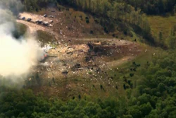 Smoke fills the air as debris covers the ground and vehicles after a powerful blast ripped through a military explosives manufacturing plant in Hickman County, Tenn., on Friday, Oct. 10, 2025.