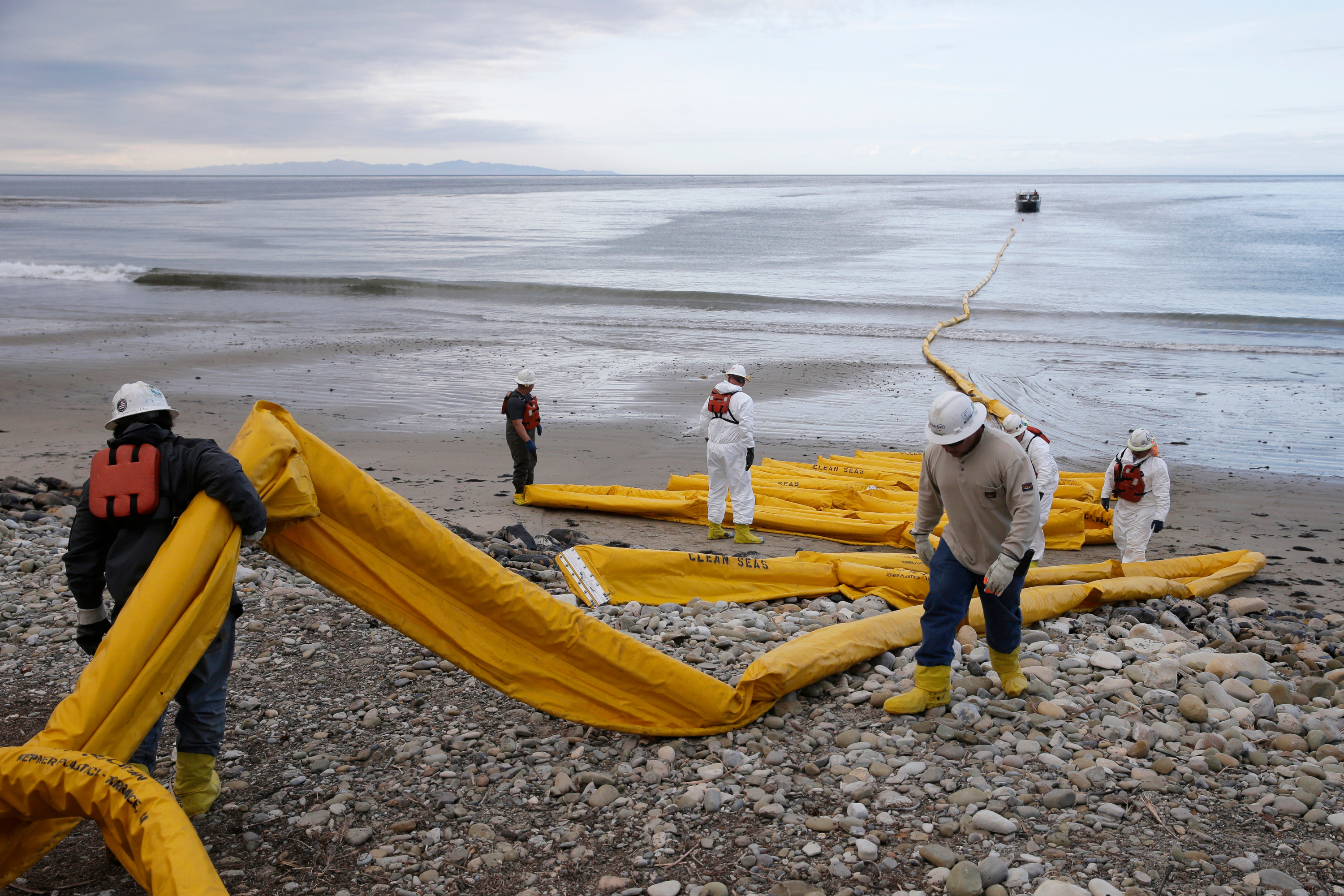 Workers prepare an oil containment boom at Refugio State Beach, north of Goleta, Calif., May 21, 2015.