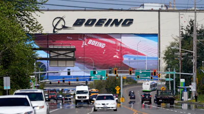 Traffic drives in view of a Boeing Co. production plant, where images of jets decorate the hangar doors on April 23, 2021, in Everett, Wash.